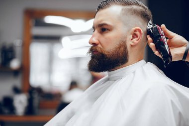 Berber dükkanında oturan şık bir adam.