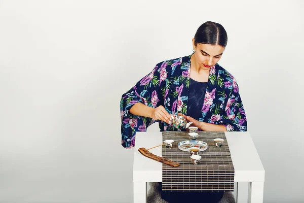 Mooi meisje een thee drinken in een studio — Stockfoto