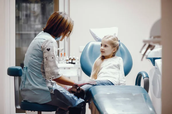 Schattig klein meisje zitten in het kantoor van de tandartsen — Stockfoto