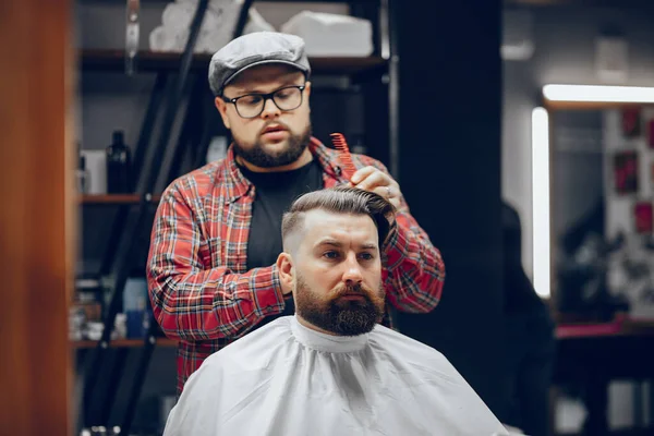 Stilvoller Mann sitzt in einem Friseurladen — Stockfoto