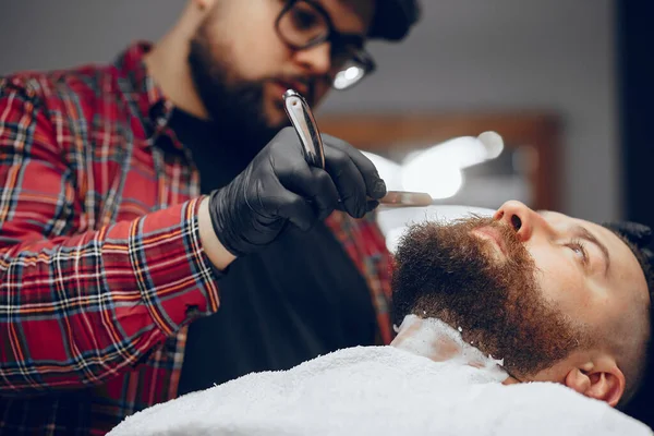 Stilvoller Mann sitzt in einem Friseurladen — Stockfoto