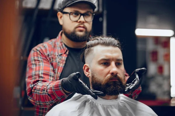 Stilvoller Mann sitzt in einem Friseurladen — Stockfoto