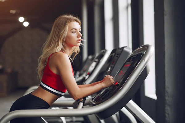 Spor salonunda spor giyinen bir sarışın. — Stok fotoğraf