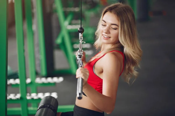 Loira de esportes em um treinamento de sportswear em um ginásio — Fotografia de Stock