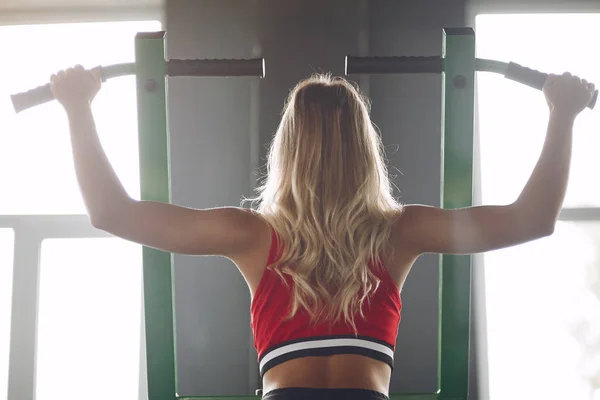 Sports blonde in a sportswear training in a gym — Stock Photo, Image