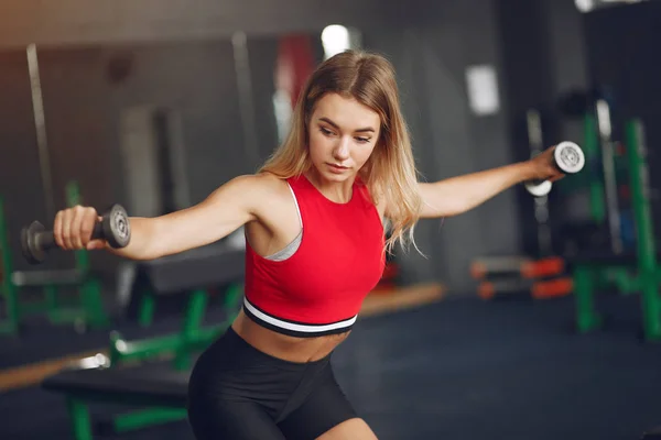 Sports blonde in a sportswear training in a gym — Stock Photo, Image