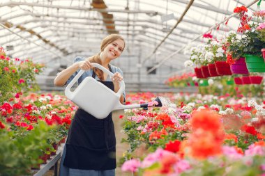 Serada çalışan siyah önlüklü bir kadın.