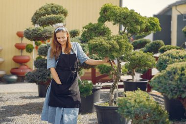 Serada çalışan siyah önlüklü bir kadın.