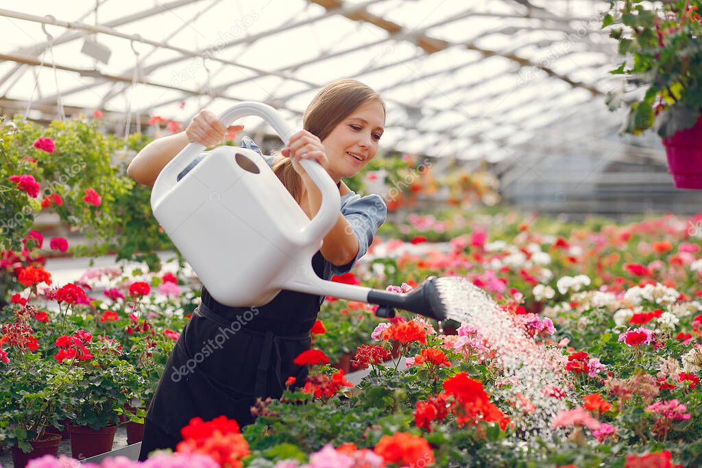 Woman in a black apron working in a greenhouse