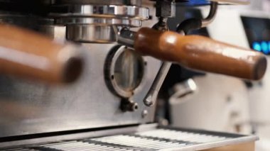 The barista is preparing steamy milk for latte in a coffee machine