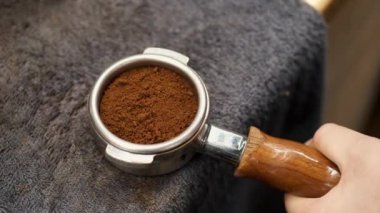 The barista is tamping grounded beans of coffee