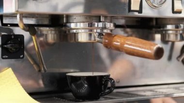 Espresso kahvesi makineden kahve bardağına dökülüyor.