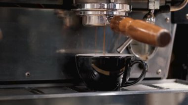 Espresso kahvesi makineden kahve bardağına dökülüyor.
