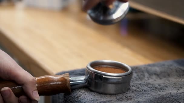 The barista is tamping grounded beans of coffee — 图库视频影像