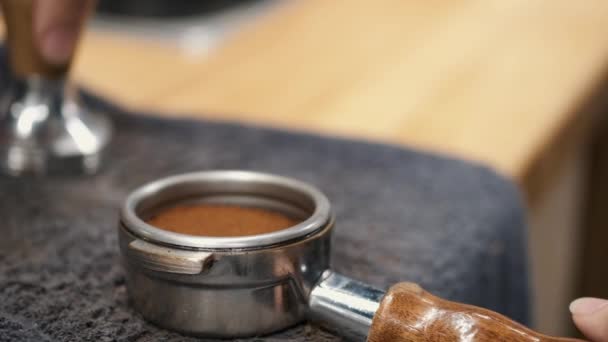 The barista is tamping grounded beans of coffee — Stok video