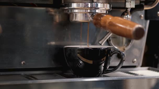 O café expresso está sendo derramado da máquina em uma caneca de café — Vídeo de Stock