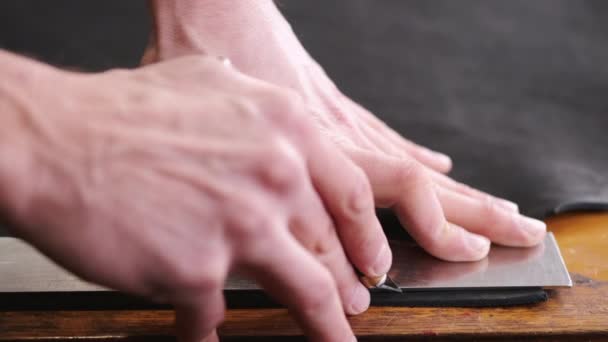 Garveren skærer sort læderplade med en barberkniv og meter – Stock-video