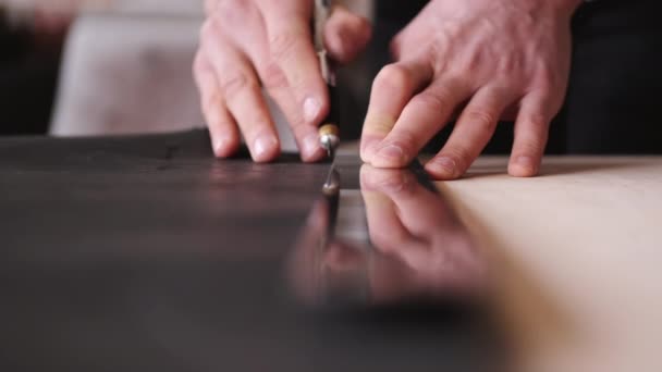 The tanner is cutting black leather sheet with a razor and metre — 비디오