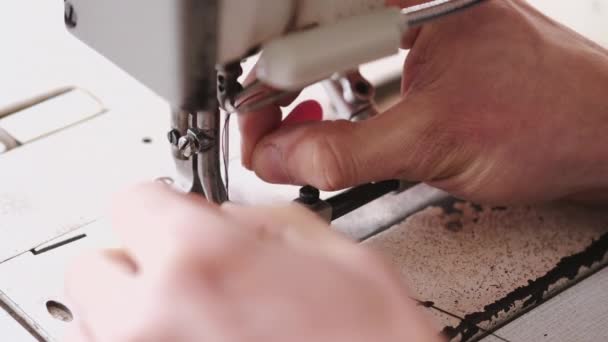 The master is preparing a sewing machine for work — Stock video