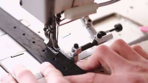 The craftsman stitches a mens leather belt on a sewing machine — Αρχείο Βίντεο