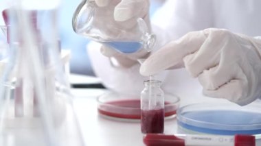 Scientist in coverall suit is making coronavirus test in a lab