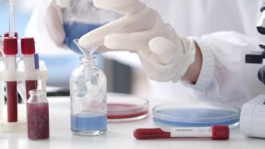 Scientist in coverall suit is making coronavirus test in a lab