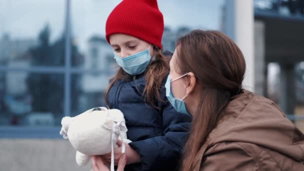 Europejska matka w respiratorze z córką stoją w pobliżu budynku — Wideo stockowe