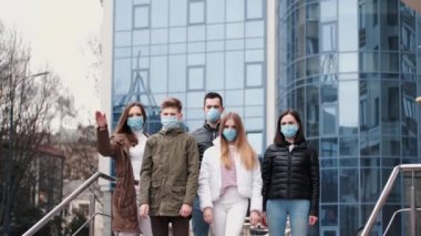 Koruyucu maskeler takan insanlar elle dur işareti gösteriyorlar.