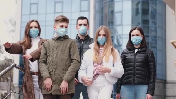 Junge Menschen mit Atemschutzmasken kreuzen die Hände — Stockvideo