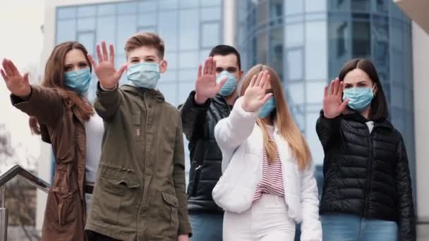 Mensen met beschermende maskers tonen stopteken door handen. — Stockvideo