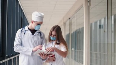 Maskeli doktorlar sorunu koridorda tartışıyorlar.