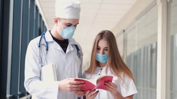 Doctors in masks are discussing the problem in a hall — Stock Video