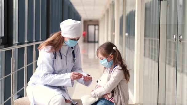 Doctor and a child in protective masks are in hospital — Stock Video