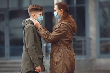 A boy and mother are wearing protective masks
