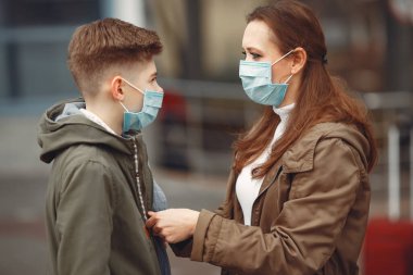 A boy and mother are wearing protective masks