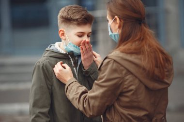 A boy and mother are wearing protective masks