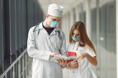 Maskeli doktorlar sorunu koridorda tartışıyorlar.