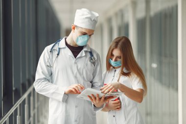 Maskeli doktorlar sorunu koridorda tartışıyorlar.