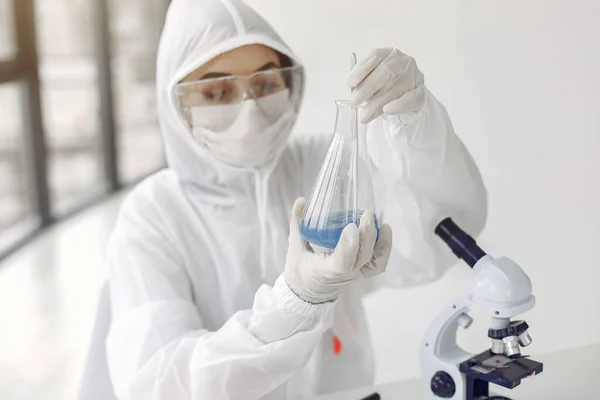 Seorang ilmuwan laboratorium sedang memeriksa larutan biru dalam botol — Stok Foto