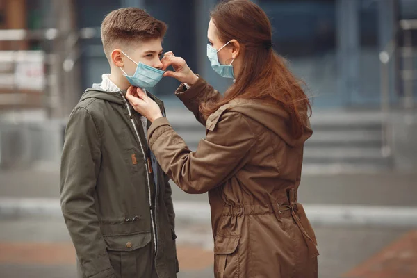 Un niño y una madre llevan máscaras protectoras. —  Fotos de Stock