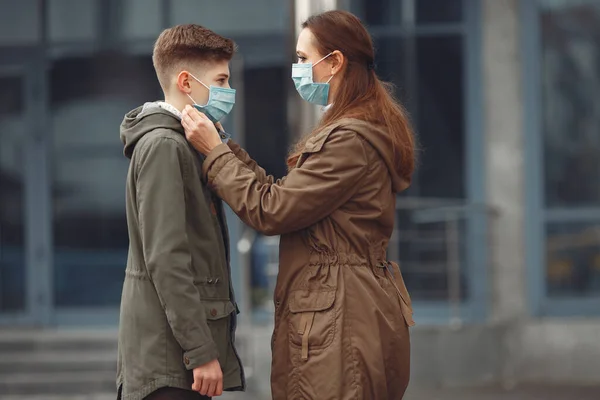Un niño y una madre llevan máscaras protectoras. —  Fotos de Stock