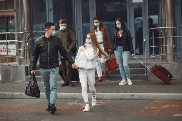Los viajeros que salen del aeropuerto llevan máscaras protectoras. —  Fotos de Stock