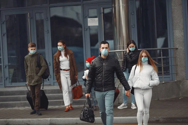 Los viajeros que salen del aeropuerto llevan máscaras protectoras. — Foto de Stock