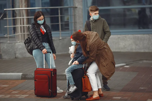Madres europeas en respiradores con niños están de pie cerca de un edificio . —  Fotos de Stock
