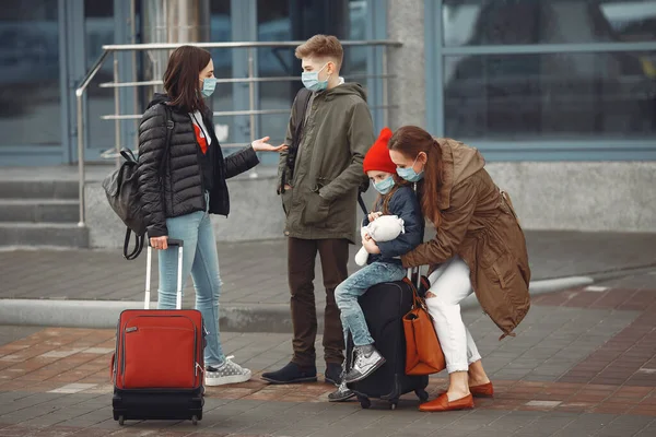 Madres europeas en respiradores con niños están de pie cerca de un edificio . —  Fotos de Stock