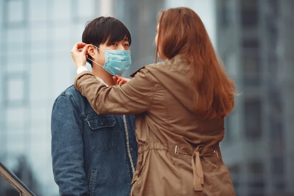 A woman and Chinese man are wearing protective masks — Stock Photo, Image