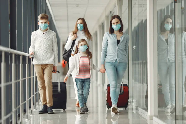 Havaalanındaki insanlar kendilerini virüsten korumak için maske takıyorlar.