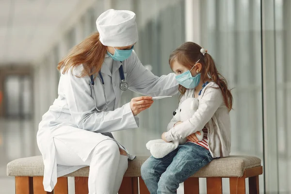 Médico y un niño con máscaras protectoras están en el hospital —  Fotos de Stock