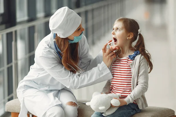 El médico con una máscara ahorra antiséptico en la garganta para un niño — Foto de Stock