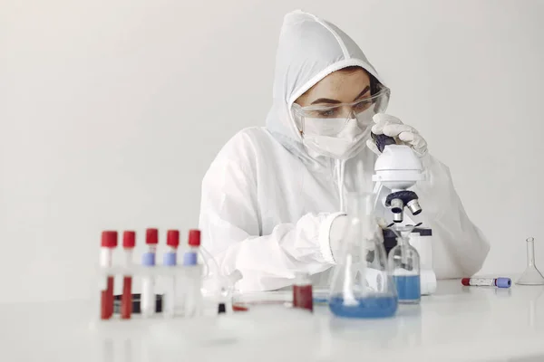 Uno scienziato di laboratorio sta esaminando una soluzione blu in una bottiglia Immagine Stock